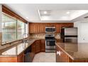 Well-lit kitchen with stainless steel appliances, granite countertops, kitchen island, and ample cabinet space at 547 E Sack Dr, Phoenix, AZ 85024