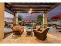 Relaxing outdoor patio area with comfortable seating overlooking a beautiful pool and lush landscaping at 560 W Powell Way, Chandler, AZ 85248