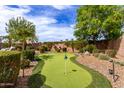 Backyard putting green with lush landscaping and manicured shrubbery at 560 W Powell Way, Chandler, AZ 85248