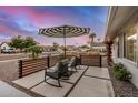 Inviting front porch showcasing cozy seating, stylish umbrella, and a relaxed outdoor ambiance at 8738 E Rose Ln, Scottsdale, AZ 85250