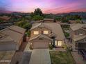 Stunning two-story home with a tile roof, lush landscaping, and mountain views at sunset at 9364 S Margo Dr, Tempe, AZ 85284