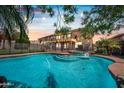 Backyard oasis with a sparkling pool, spa, privacy fence, and string lights for evening enjoyment at 9364 S Margo Dr, Tempe, AZ 85284