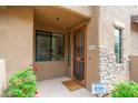 Inviting front entrance with an intricate security door, desert landscaping, and a visible security system at 13300 E Via Linda -- # 1054, Scottsdale, AZ 85259