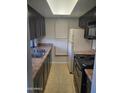 Functional kitchen with ample counter space, dark cabinetry, and white appliances at 1449 E Highland Ave # 39, Phoenix, AZ 85014
