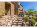 Inviting home exterior showcasing rock landscaping, desert foliage, and a pathway leading to the front door at 16600 N Thompson Peak Pkwy # 1072, Scottsdale, AZ 85260