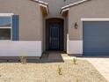 Close-up view of the home's entryway with a blue front door and neutral stucco at 17621 W Pierson St, Goodyear, AZ 85395