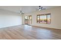 Bright living room featuring sleek flooring, modern ceiling fans, and sliding doors to the backyard at 21913 N Pedregosa Ct, Sun City West, AZ 85375