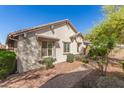 Side view of a well-kept beige single-story home featuring mature landscaping at 2580 E Boston St, Gilbert, AZ 85295