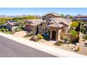 Elegant desert home with lush desert landscaping, a tile roof and spacious driveway leading to the two-car garage at 26015 N 85Th Dr, Peoria, AZ 85383