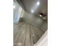 Bright living room featuring wood-look floors, a ceiling fan, and natural light from large windows at 2662 N 43Rd Ave # B, Phoenix, AZ 85009