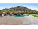 Backyard view of the sparkling pool, integrated hot tub, putting green, and beautiful desert mountain view at 3529 N Boulder Canyon St, Mesa, AZ 85207