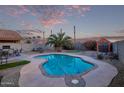 This backyard has a pool, putting green, desert landscaping, and outdoor dining area at 36469 W Alhambra St, Maricopa, AZ 85138