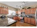 Well-lit kitchen with custom wood cabinets, stainless steel appliances, and granite countertops at 36469 W Alhambra St, Maricopa, AZ 85138