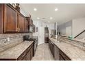 Spacious kitchen features stone countertops, tiled backsplash, stainless steel appliances, and lots of cabinet space at 38085 W San Capistrano Ave, Maricopa, AZ 85138