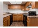 Kitchen featuring wood cabinets, countertops, modern appliances, and luxury flooring at 3810 N Maryvale Pkwy # 2029, Phoenix, AZ 85031
