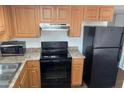 Kitchen features wooden cabinets, modern appliances and a new microwave at 3810 N Maryvale Pkwy # 2029, Phoenix, AZ 85031