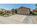 Inviting single-story home featuring a two-car garage and desert landscaping with a paved driveway at 4665 E Goldfinch Gate Ln, Phoenix, AZ 85044