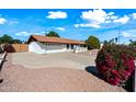 Lovely home with a circular driveway and well-maintained desert landscaping with shrubbery and a tile roof at 5434 E Acoma Dr, Scottsdale, AZ 85254