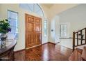 Bright foyer featuring hardwood floors, a wooden front door, and views into other rooms at 6925 W Tonto Dr, Glendale, AZ 85308