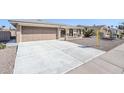 A long driveway leads to a well-maintained home with a two-car garage at 8320 E Nido Ave, Mesa, AZ 85209