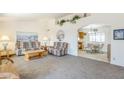 Open-concept living room with comfortable seating, neutral carpeting, and easy access to the kitchen at 8320 E Nido Ave, Mesa, AZ 85209