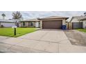 Exterior of a brick home featuring a two-car garage, lush green lawn, and a paved driveway at 903 W Barrow Dr, Chandler, AZ 85225