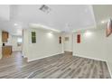 Bright living room with laminate flooring and recessed lighting next to a dining area at 9230 N 82Nd Ln, Peoria, AZ 85345