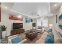 Bright living room features a ceiling fan, large windows, neutral tones and comfortable seating at 9230 N 82Nd Ln, Peoria, AZ 85345