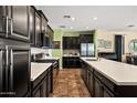 Modern kitchen with stainless steel appliances, white countertops, and sleek, dark cabinetry at 10635 W Eucalyptus Rd, Peoria, AZ 85383
