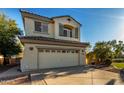 Well-kept two-story residence with tan siding, a two-car garage, and a manicured lawn at 11713 W Tonto St, Avondale, AZ 85323