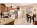 Open kitchen with wood cabinets, granite counters, and stainless appliances at 15074 W Cactus Ridge Way, Surprise, AZ 85374