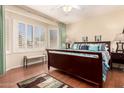 Sunlit main bedroom boasts hardwood floors, plantation shutters, and a comfortable seating bench by the bay windows at 15074 W Cactus Ridge Way, Surprise, AZ 85374