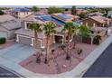 Stunning aerial view of a home highlighting solar panels, mature palm trees, a private backyard with a waterfall feature at 15123 W Custer Ln, Surprise, AZ 85379
