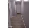 Hallway with durable wood flooring, neutral paint, and access to multiple rooms at 1875 N St Francis Pl, Casa Grande, AZ 85122