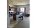 Modern kitchen with stainless steel appliances, center island, and wood cabinetry with breakfast bar seating at 19427 N Toya St, Maricopa, AZ 85138