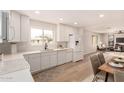 Bright, updated kitchen with white cabinets, modern appliances, and quartz countertops overlooking the living area at 2408 W Flower St, Phoenix, AZ 85015