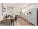 Clean, white kitchen featuring stainless steel appliances, quartz counters and wood-look flooring adjacent to the dining area at 2408 W Flower St, Phoenix, AZ 85015