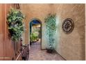 Charming courtyard entrance with stone pavers, decorative lighting, and an arched hallway at 27280 N Makena Pl, Peoria, AZ 85383