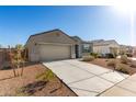 Single-story home with a spacious driveway, desert landscaping, and an attached two-car garage at 30323 W Sheila Ln, Buckeye, AZ 85396