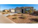 Quaint single-story house with well-manicured desert landscaping and blue shutters at 30323 W Sheila Ln, Buckeye, AZ 85396