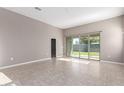 Bright living room featuring tile flooring and sliding glass doors that lead to the backyard at 30323 W Sheila Ln, Buckeye, AZ 85396