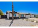 This cozy home features an attached two-car garage, desert landscaping, and a bright yellow front door at 3437 E Acoma Dr, Phoenix, AZ 85032