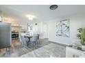 Open-concept dining area featuring modern decor, a round table with gray chairs, and stainless steel appliances at 4128 W Las Palmaritas Dr, Phoenix, AZ 85051
