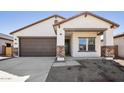 Charming single-story home showcasing a two-car garage, stone accents, and inviting front entrance at 42405 W Krista Dr, Maricopa, AZ 85138