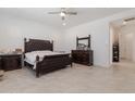 A spacious main bedroom features a ceiling fan, tile flooring, and dark wood furniture at 5226 W Thresher Way, Laveen, AZ 85339