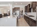 Well-lit open kitchen featuring a center island, stainless steel appliances, and walk-in pantry at 5226 W Thresher Way, Laveen, AZ 85339