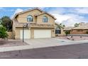 A two-story home with a two-car garage, desert landscaping, a basketball hoop, and a tile roof at 53 W Pecan Pl, Tempe, AZ 85284
