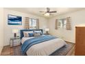 Cozy main bedroom with comfortable bed, ceiling fan, and two sunny windows at 5323 E Dodge St, Mesa, AZ 85205