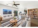 Bright living room boasts a cozy sofa, a ceiling fan, and an open floor plan adjacent to the kitchen at 5719 E Santa Clara Dr, San Tan Valley, AZ 85140