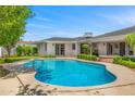 Inviting kidney-shaped pool surrounded by a brick patio and green landscaping at 6231 E Calle Camelia --, Scottsdale, AZ 85251